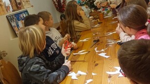 uczniowie wykonują ozdobne anioły z papieru
