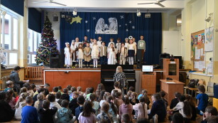 dzieci śpiewają przed uczniami